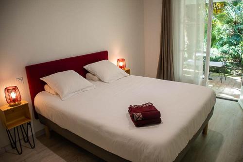 a bedroom with a bed with a red bag on it at Au détour des vignes in Ordonnac