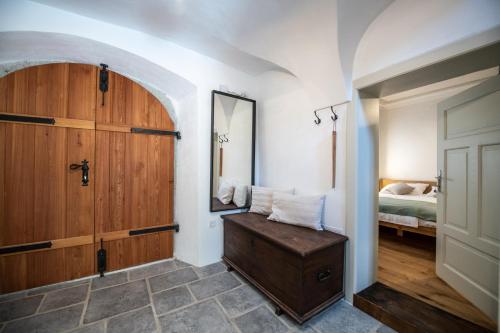 a bedroom with a wooden door and a bed at MEŽNARIJA Radovljica in Radovljica