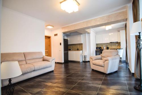 a living room with two couches and a kitchen at Apart hotel Victor 203 in Mamaia