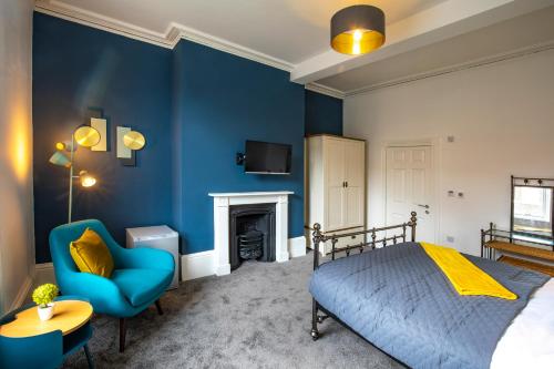 a bedroom with blue walls and a bed and a chair at BrickSage Rooms, King's Lynn South Gate in King's Lynn