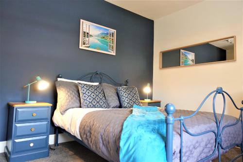 a bedroom with a blue bed and a blue dresser at BrickSage Rooms, King's Lynn South Gate in Kings Lynn
