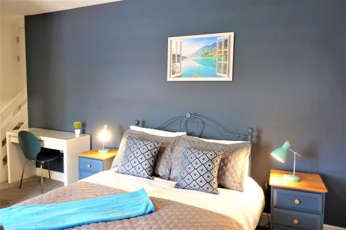 a bedroom with a bed and a desk with a desk at BrickSage Rooms, King's Lynn South Gate in King's Lynn