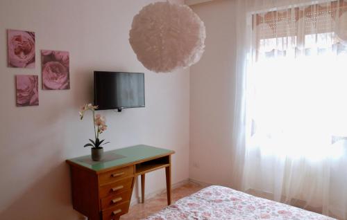 a bedroom with a bed and a desk and a tv at CASA PAOLINA NEL CENTRO DI BRACCIANO in Bracciano