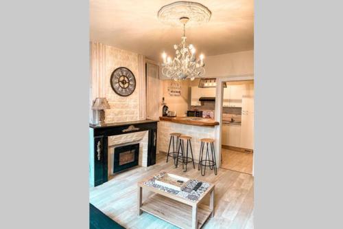 d'un salon avec une cheminée et un lustre. dans l'établissement Appartement familial de caractère, à Boulogne-sur-Mer