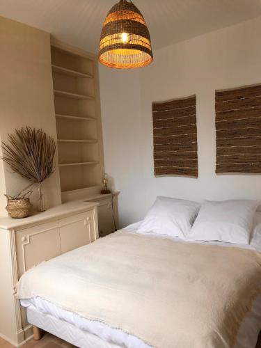 - une chambre avec un lit blanc et une plante en pot dans l'établissement Le Tanin -Appartement entier avec Balcon, à Saumur