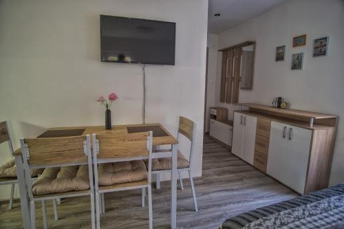 a kitchen and dining room with a table and a television at BIKE apartments 2 in Hodruša