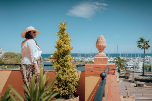 a woman standing on a wall with a plant at Ermitage de l'Oasis & Spa - Cannes Mandelieu in Mandelieu-la-Napoule