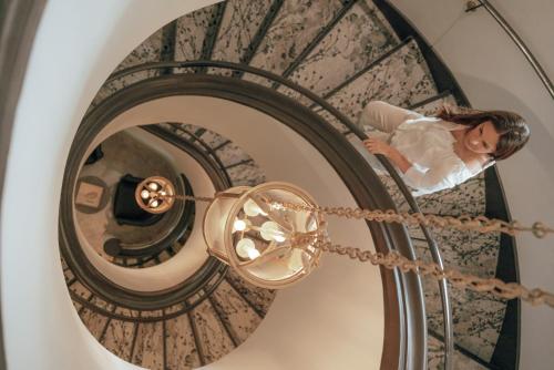 a bride walking up the spiral staircase of a building at Ermitage de l'Oasis & Spa - Cannes Mandelieu in Mandelieu-la-Napoule