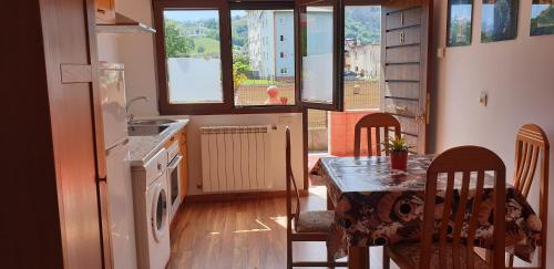 Apartamentos Fermín في كانغاس دي أونيس: مطبخ مع طاولة وكراسي ومطبخ مع حوض