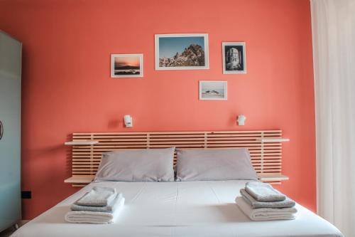 a bedroom with orange walls and a bed with towels on it at Magna Grecia B&B e Appartamenti in Caulonia Marina