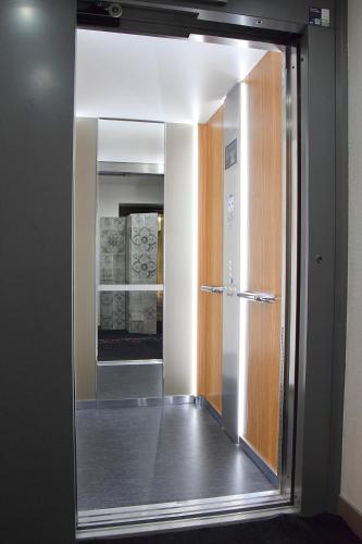 - un couloir avec un miroir dans l'établissement Hotel des Lauriers Roses, à Bourbonne-les-Bains