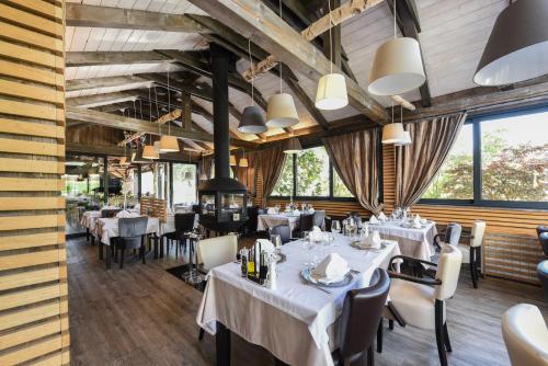 a restaurant with white tables and chairs and large windows at Lakeside Hotel Plitvice in Plitvička Jezera