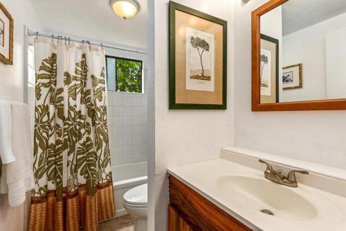 a bathroom with a sink and a shower curtain at MAILAN HALE II in Kailua-Kona