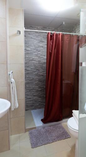 a bathroom with a shower with a red shower curtain at Hostal Yebisah in Santa Eularia des Riu