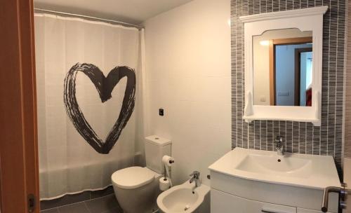 a bathroom with a heart sign on the wall at Apartamento en Piles Playa in Piles