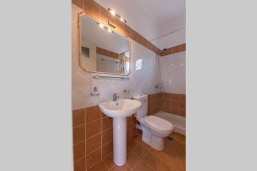 W łazience znajduje się umywalka, toaleta i lustro. w obiekcie Elafonisos Amazing View w Elafónisos