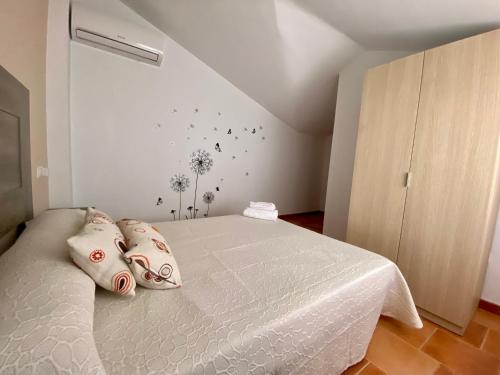 1 dormitorio con 1 cama blanca y 4 almohadas en Alojamiento Los Tejos - Arroyo Frío, en Arroyo Frío