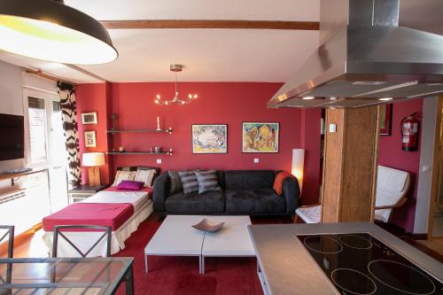 a living room with red walls and a couch at DUPLEX CON VISTAS AL MAR,WIFI Y PARKING in San Vicente de la Barquera