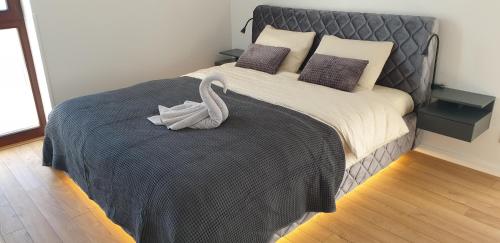 a bedroom with a bed with a swan on it at Lighthouse Apartment Šventosios Vartai in Palanga