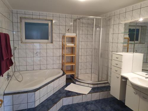 a bathroom with a tub and a shower and a sink at Ferienhaus Deutschmann in Sankt Johann im Pongau