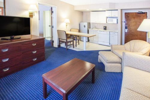 a living room with a couch and a tv and a table at Wyndham Garden Monterrey Norte in Monterrey