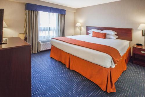 a hotel room with a large bed and a window at Wyndham Garden Monterrey Norte in Monterrey