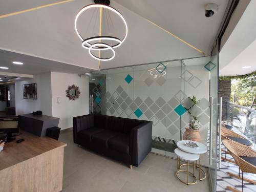 a living room with a black couch and a table at Hostel Boutique Nido de Loros in Medellín