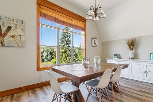 a dining room with a wooden table and white chairs at Blue Mountain 3 bedroom Dream Chalet 81590 in Collingwood