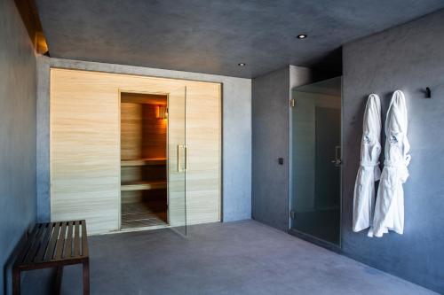 a hallway with a wooden bench and a glass door at Memmo Baleeira - Design Hotels in Sagres