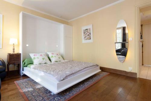 um quarto com uma cama branca e uma janela em Paris Saint Michel Sorbonne em Paris
