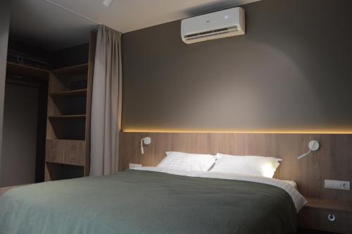 a bedroom with a bed with a air conditioner on the wall at Fisherman in Kyiv