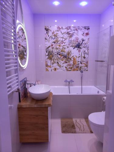 a bathroom with a tub and a sink and a bath tub at Leśny Kąt in Ustka