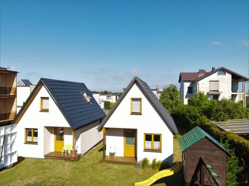 grupa białych domów z żółtymi drzwiami w obiekcie Domek AMPERO 2 we Władysławowie