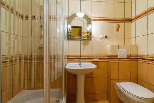 a bathroom with a sink and a shower and a toilet at Pensjonat pod Giewontem in Zakopane