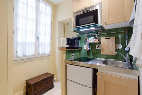 une cuisine avec un évier et un micro-ondes dans l'établissement Paris Saint Michel Sorbonne, à Paris