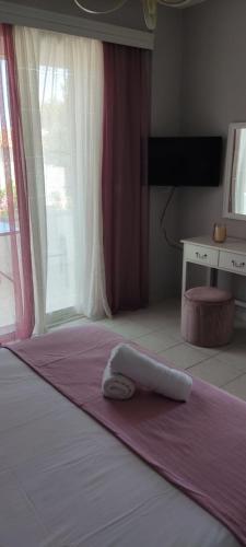 una camera da letto con un letto e un asciugamano sopra di SIMPLICITY a Marmári