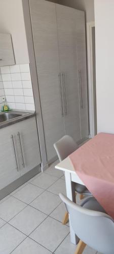 a kitchen with a pink table and white cabinets at SIMPLICITY in Marmari