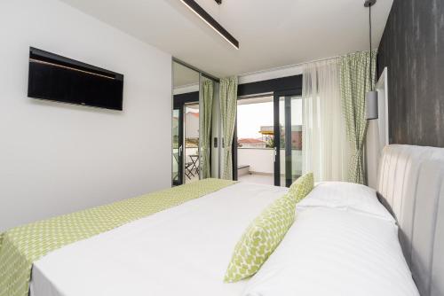 a bedroom with two beds and a tv at Luxury Villas Joy in Novalja