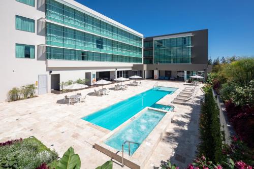 an exterior view of a building with a swimming pool at Holiday Inn - Quito Airport, an IHG Hotel in Tababela