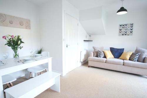 a white living room with a couch and a table at Bank Side House by KVM Serviced Accommodation in Peterborough