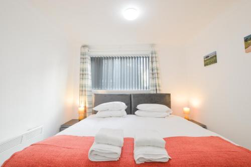 ein Schlafzimmer mit einem großen Bett mit weißen Laken und Kissen in der Unterkunft No 8 Westbay Apartment in Oban