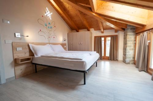 1 dormitorio con 1 cama en una habitación con techos de madera en B&B da Sabry e Gian en Comano Terme