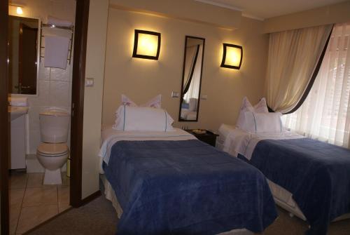 pokój hotelowy z 2 łóżkami i toaletą w obiekcie Villa Baviera, Hotel Baviera Chile w mieście La Máquina
