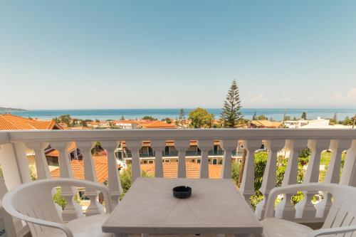 a table on a balcony with a view of the ocean at All In Krinas Apart-Hotel in Argasi
