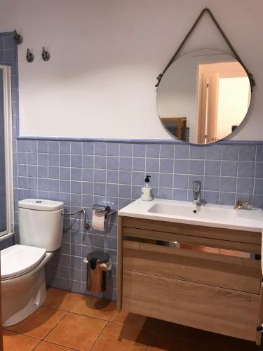a bathroom with a toilet and a sink and a mirror at Apartamento Casas del Mar in Oliva