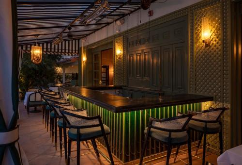a bar with a row of chairs in a restaurant at The Colony Palms Hotel and Bungalows - Adults Only in Palm Springs