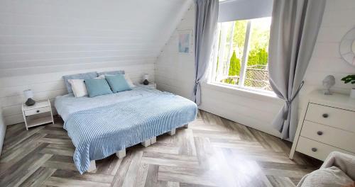 a bedroom with a bed with blue pillows and a window at Żółte Drzwi Sucha Rzeczka in Sucha Rzeczka