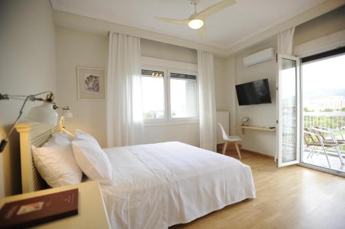 Habitación blanca con cama y balcón. en Sea & City views, Aspa’s apartment en Tesalónica