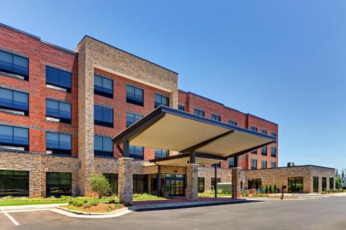 an empty parking lot in front of a brick building at Holiday Inn Express & Suites - Winston - Salem SW - Clemmons by IHG in Clemmons