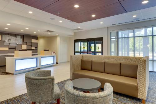 a lobby with a couch and chairs and a kitchen at Holiday Inn Express & Suites - Winston - Salem SW - Clemmons by IHG in Clemmons